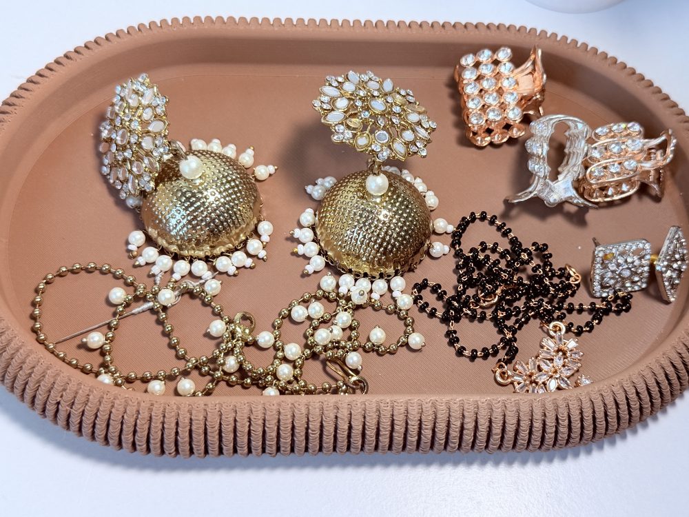 Woven-texture oval jewellery tray holding earrings, rings and necklaces